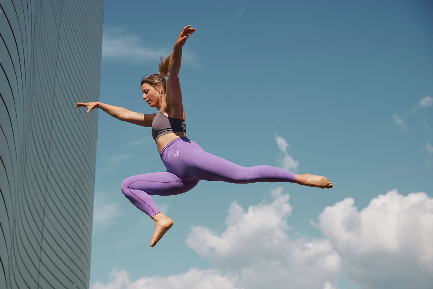 Girl doing gymnastics in an urban outdoor landscape, at the Landessportzentrum and against a summer sky