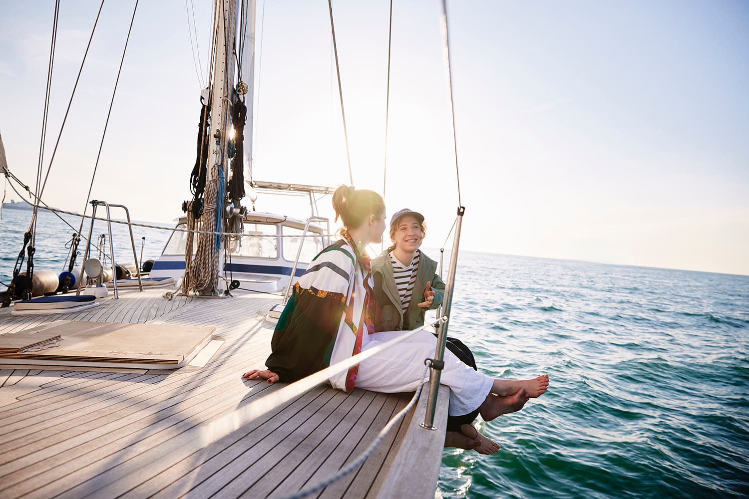 Two girls enjoying their sailing trip into the sunset near Trieste, Italy